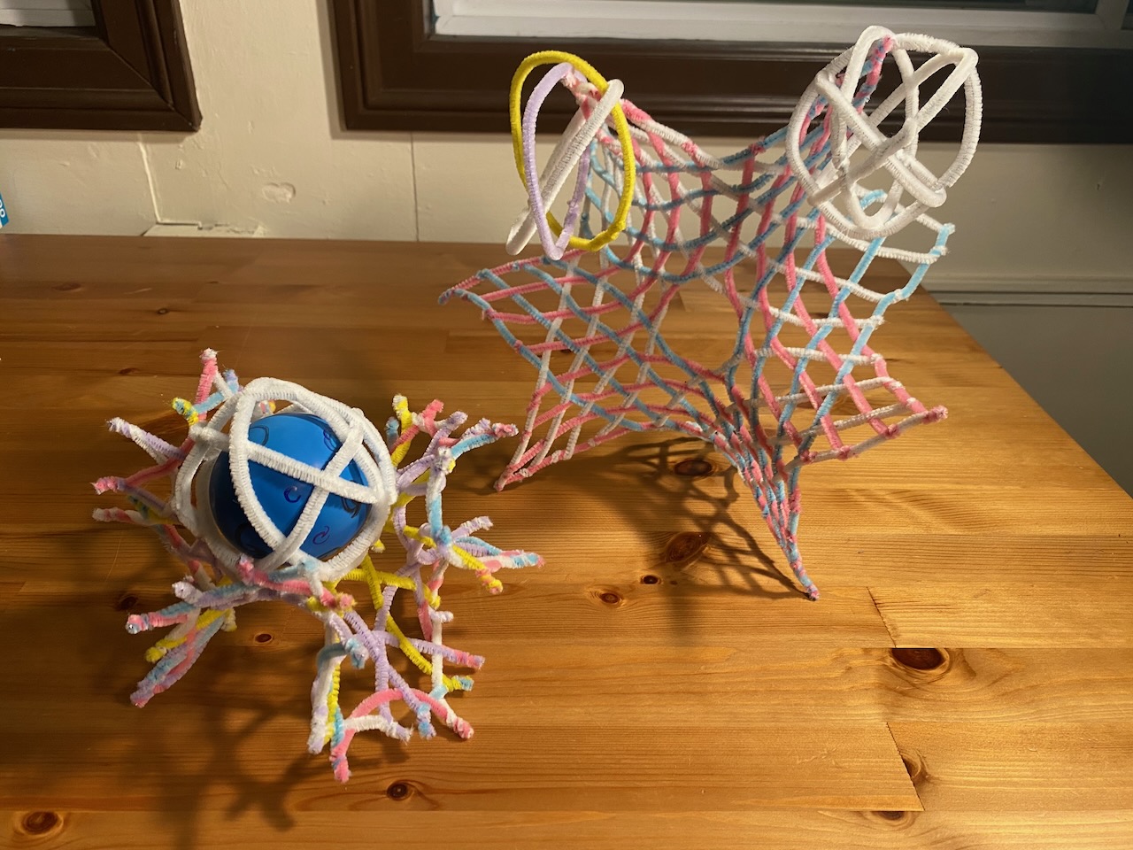 a  collection of woven pipe cleaners, popping into three dimensions