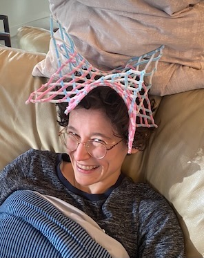 mischevious looking human wearing pipe cleaners as a hat