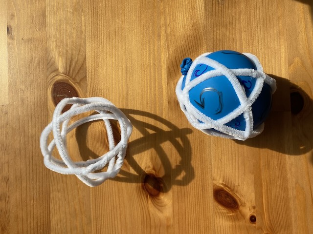 two pipe cleaner spheres, one with a balloon in it