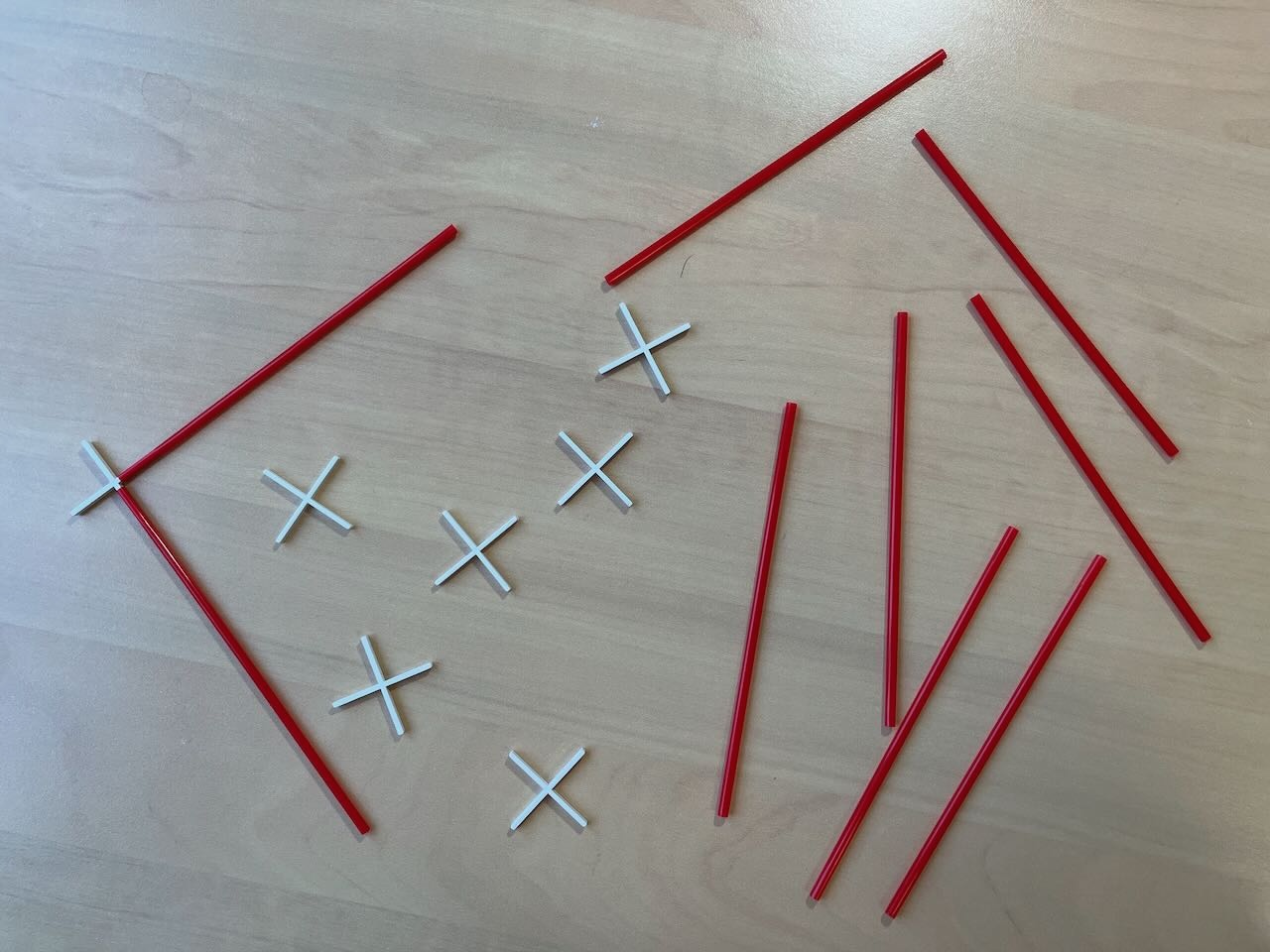 a colection of red straws and plastic plus signs. The straws fit on the end of the plus signs.