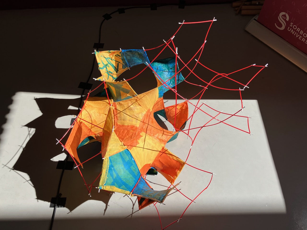 A bunch of straws going every which way, with paper stretched between. 