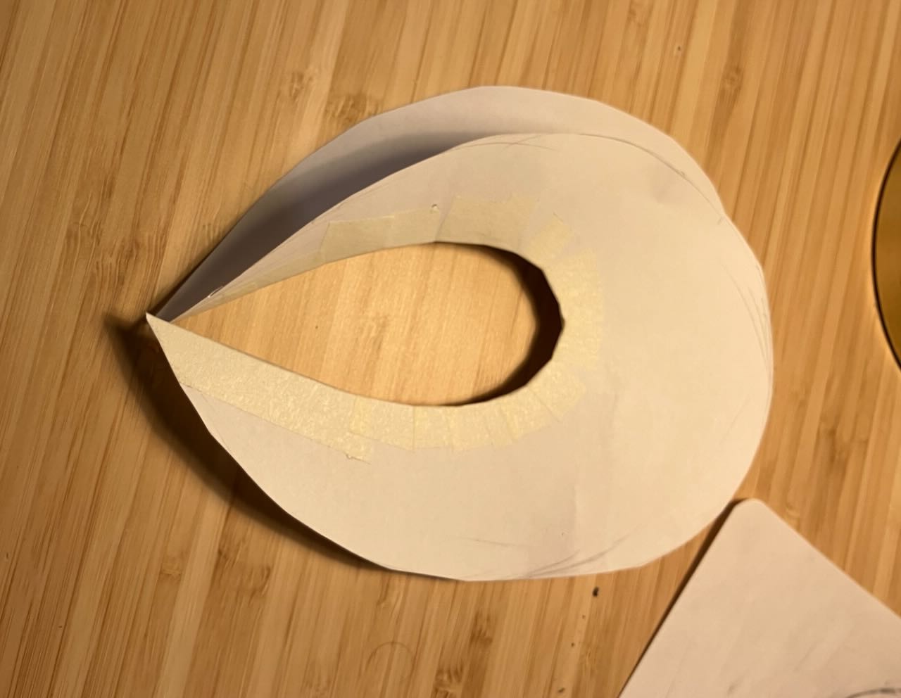 a lune out of paper. There are two layers, taped along a central curve.