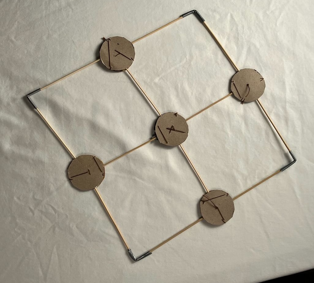 a cardboard and wooden skewer model of 4 units of the grid. It lays flat in the plane